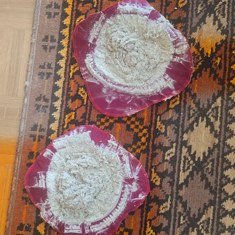 Zwei Staubfilter auf einem orange gemusterten Teppichläufer, der untere am unteren Bildrand angeschnitten